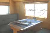 Photo shows dining table and upholstered bench seats in 1949 Curtis Wright Trailer